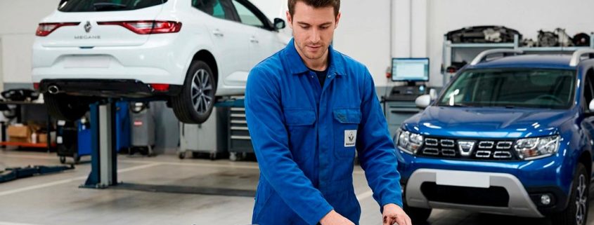 Un mecánico compara componentes de mantenimiento de coche diésel vs. gasolina (inyector, bujías) en un taller con un Renault y un Dacia.